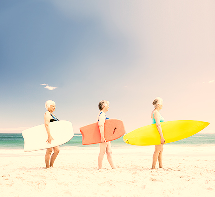 Senior woman friends holding surfboard